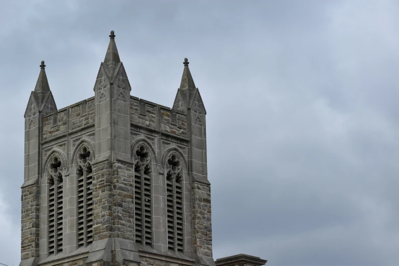 an old stone church steeple is shown on the sky