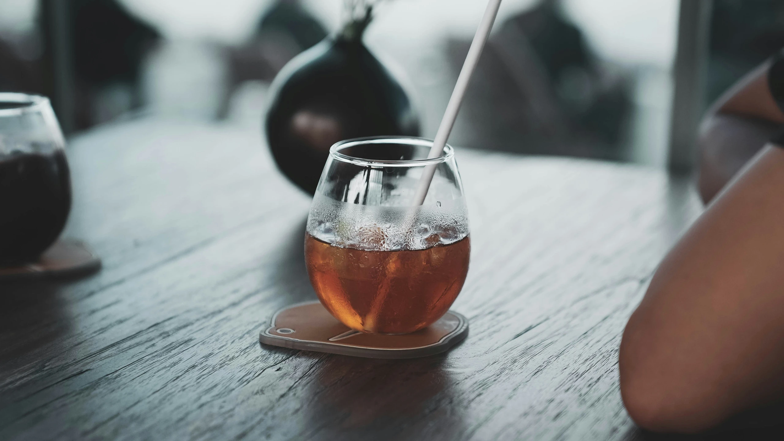 there is a glass on the table next to an empty teacup