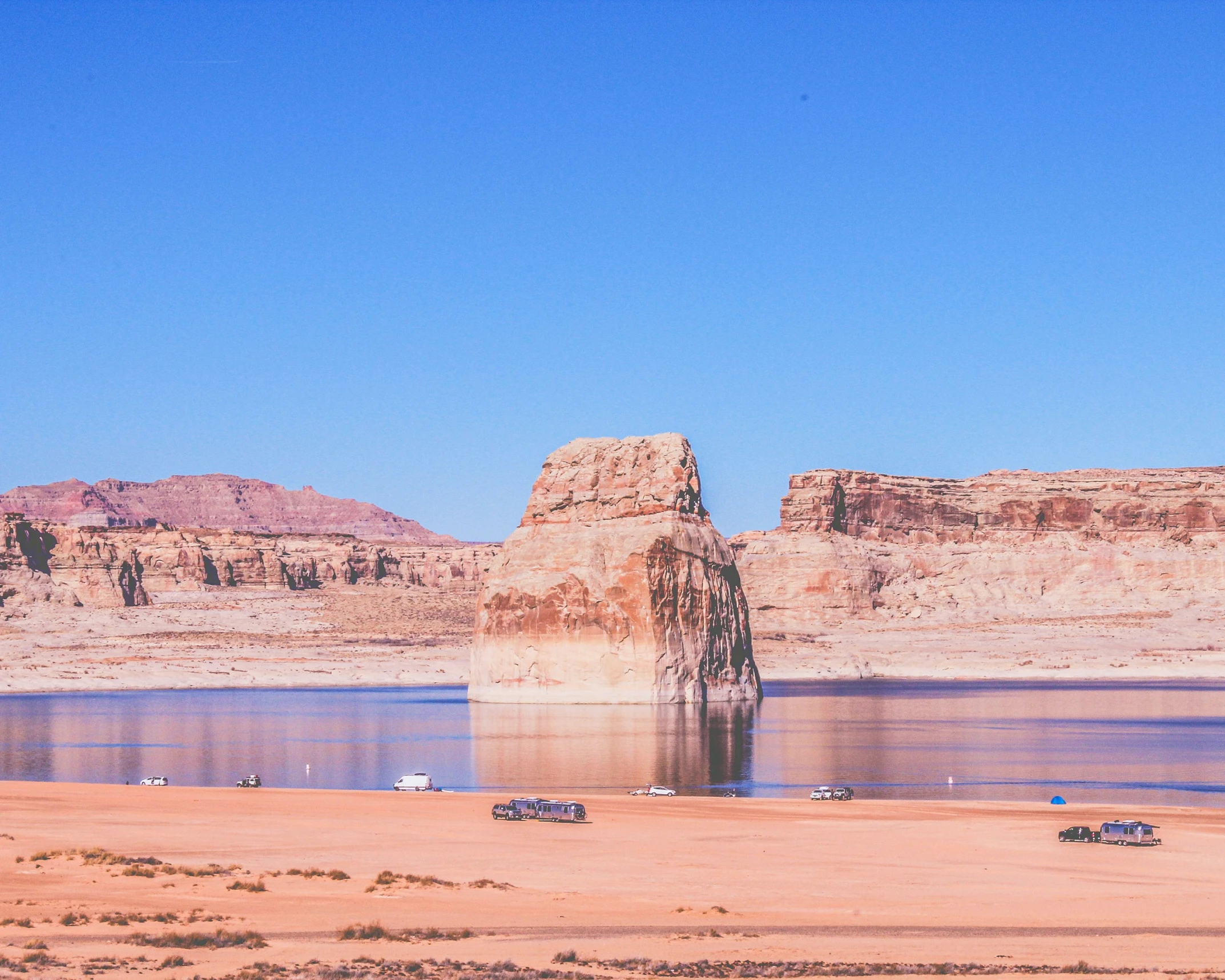 there are two desert like structures with water in the foreground