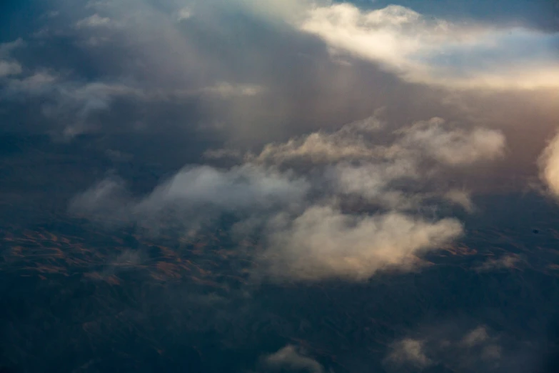 a bird flying under the sky and clouds