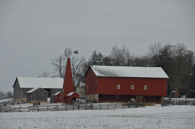 some red barns and farm buildings in the snow