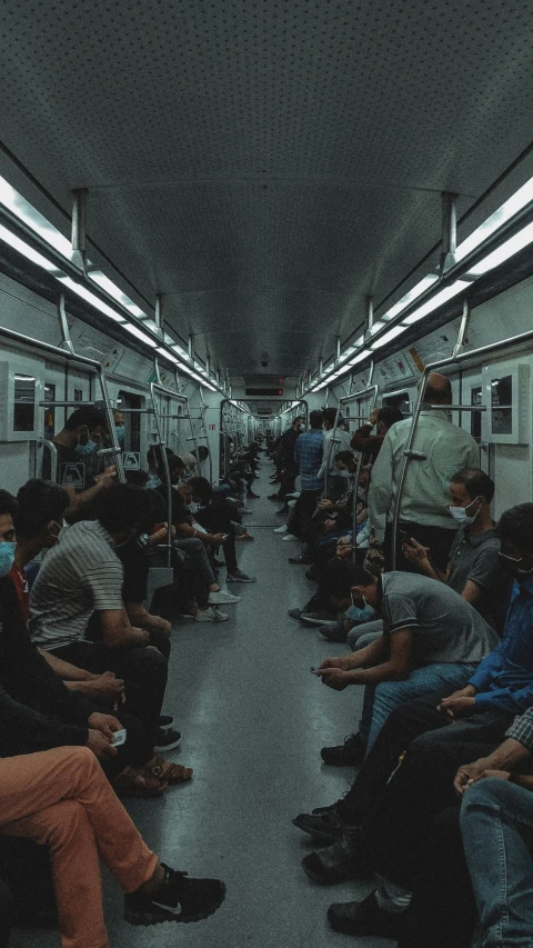 a bunch of people sitting on a train in a crowded area