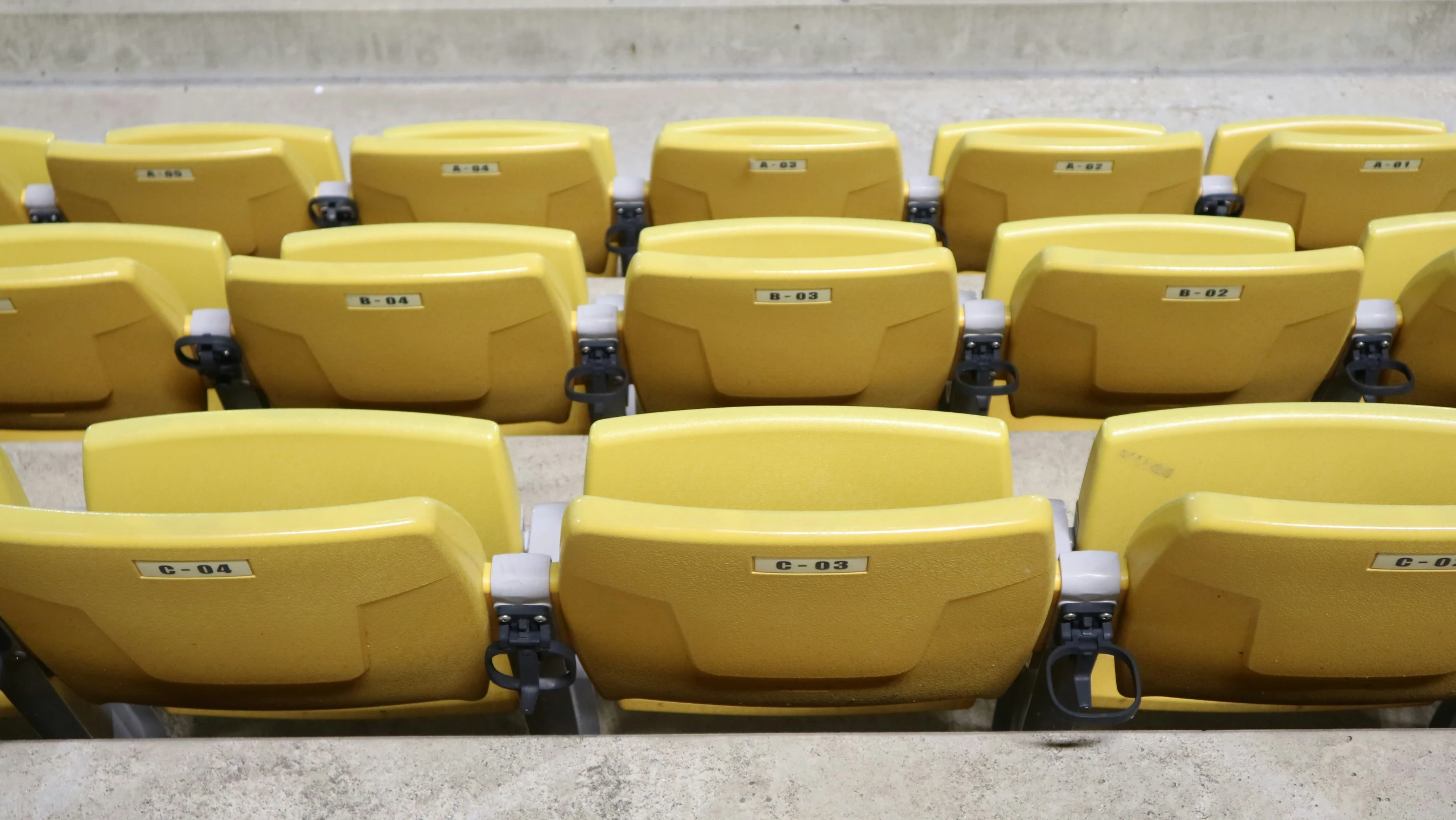 rows of seats with seat numbers and seat cover on them