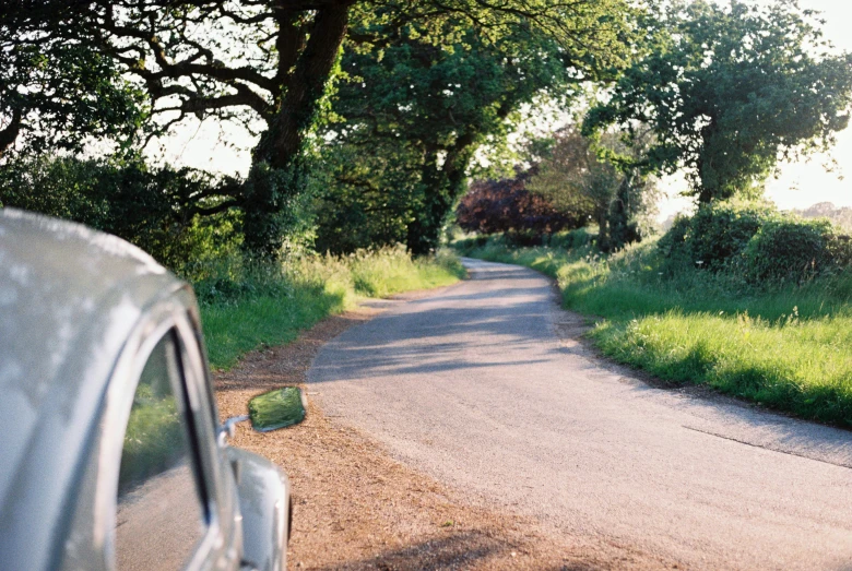 the view of the back door of a car driving along a rural road