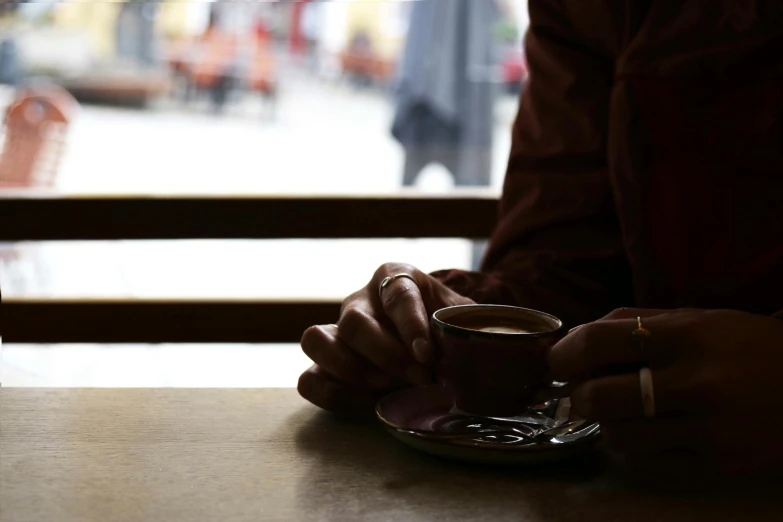 the person is holding a coffee cup at a table