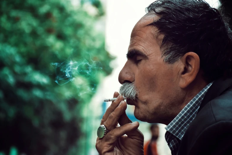 a man smoking a cigarette with his chin on the ground