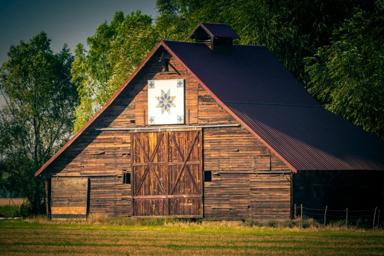 a barn with wood sidings and a weather vane on it's roof