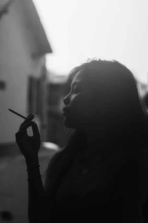 a woman that is holding a cigarette in her hand