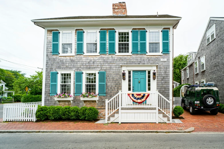 a large grey house has an american flag dd on the door and side