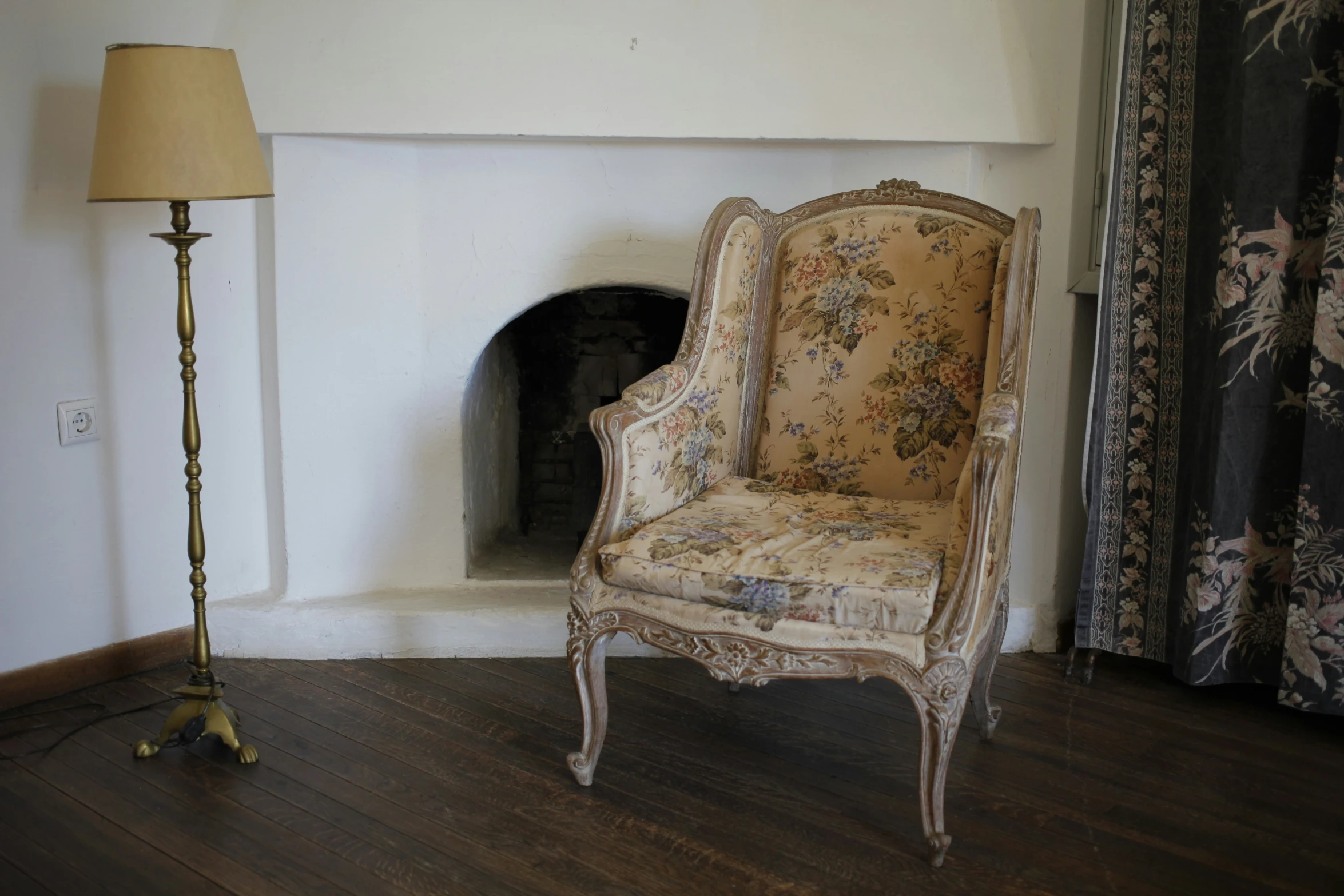 an ornate chair sitting in front of a fireplace