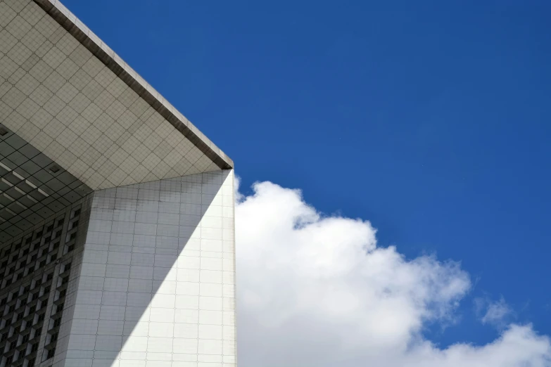 a plane flying in the air near a white building