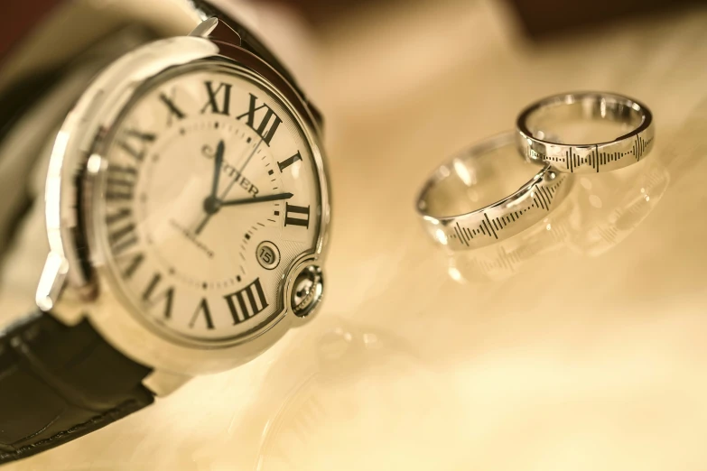 the watches and ring are sitting on a table