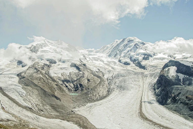 mountains covered in snow under clouds and a sky