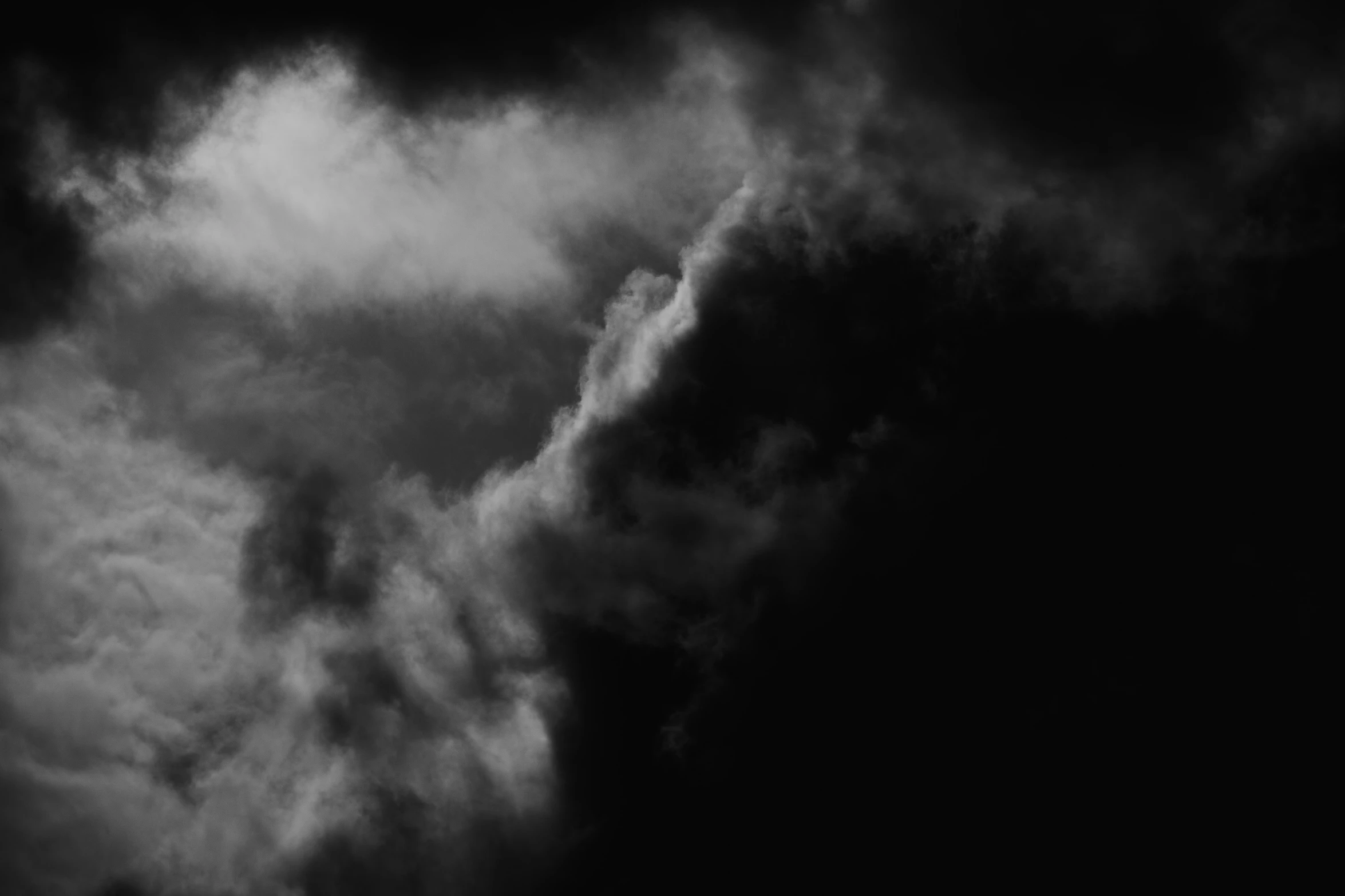 a plane flying through a cloudy sky with dark clouds