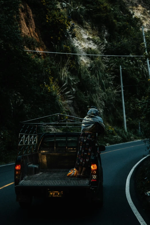 a person sitting in the back of an suv on the side of a road