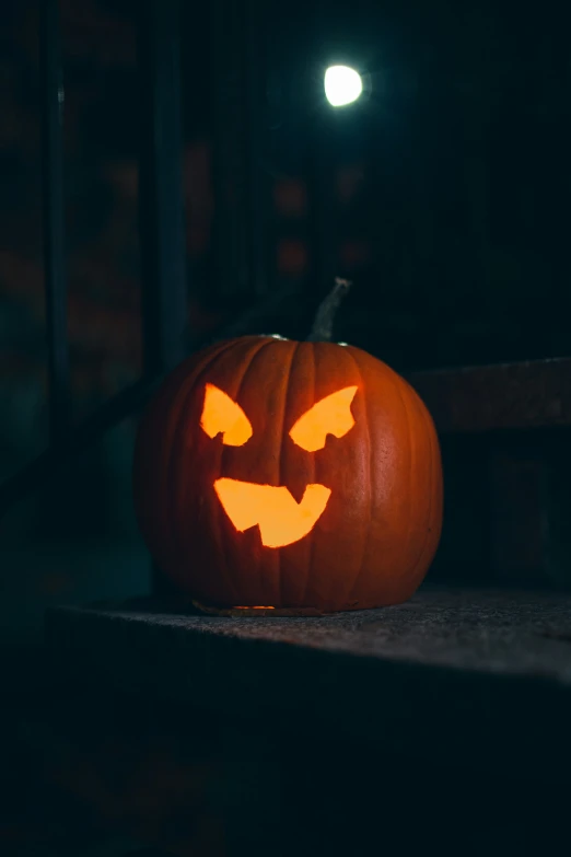 a pumpkin with an glowing face on top