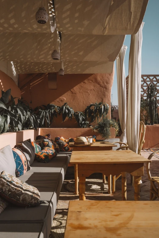 a room with couches and tables that have pillows and throw pillows on them