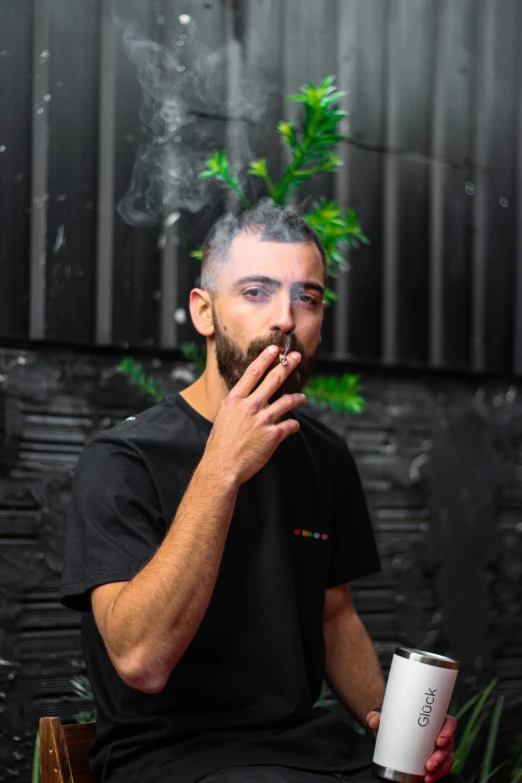 man holding up a coffee cup as smoke comes out of his mouth