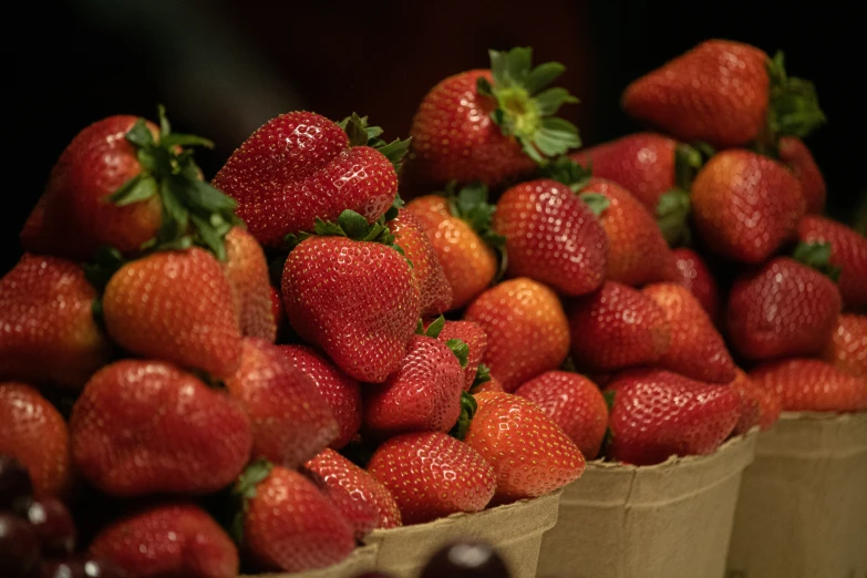 a paper bag filled with lots of red strawberries