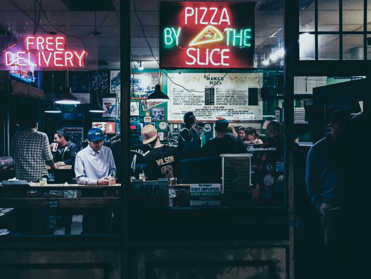 people sitting at the booths inside a pizza parlor