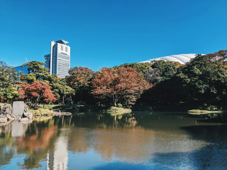 a tall white building sitting over a pond