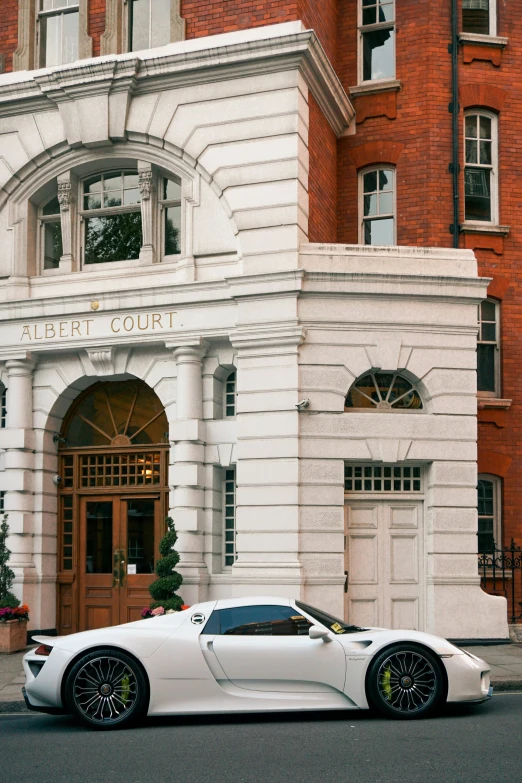 a white sports car parked in front of a building