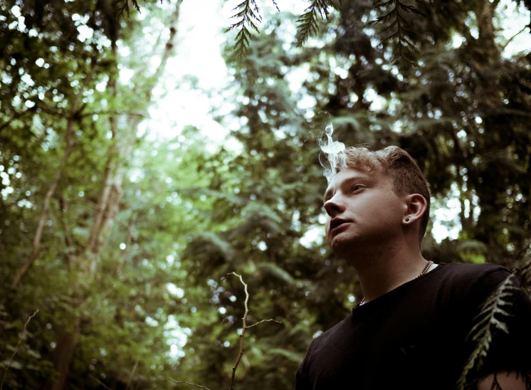 a young man wearing a black shirt and looking away