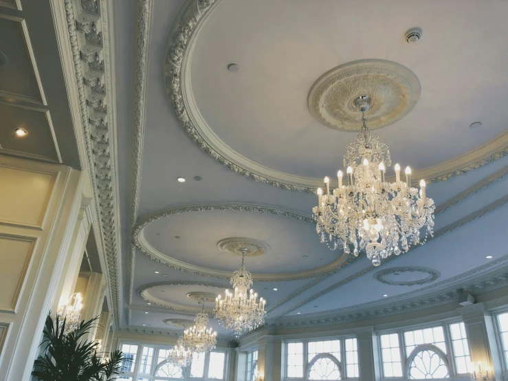 a fancy chandelier in a ballroom surrounded by floor to ceiling windows