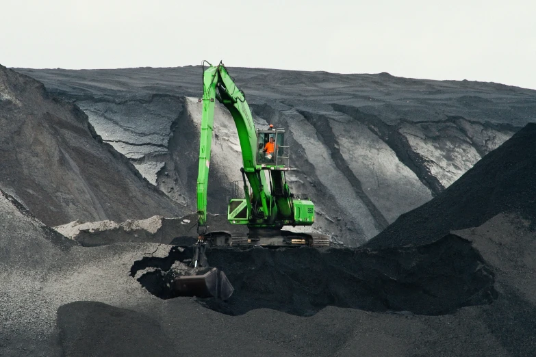 a large construction truck next to some large mounds