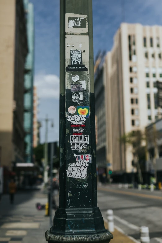 there is a close up of the street pole with stickers on it