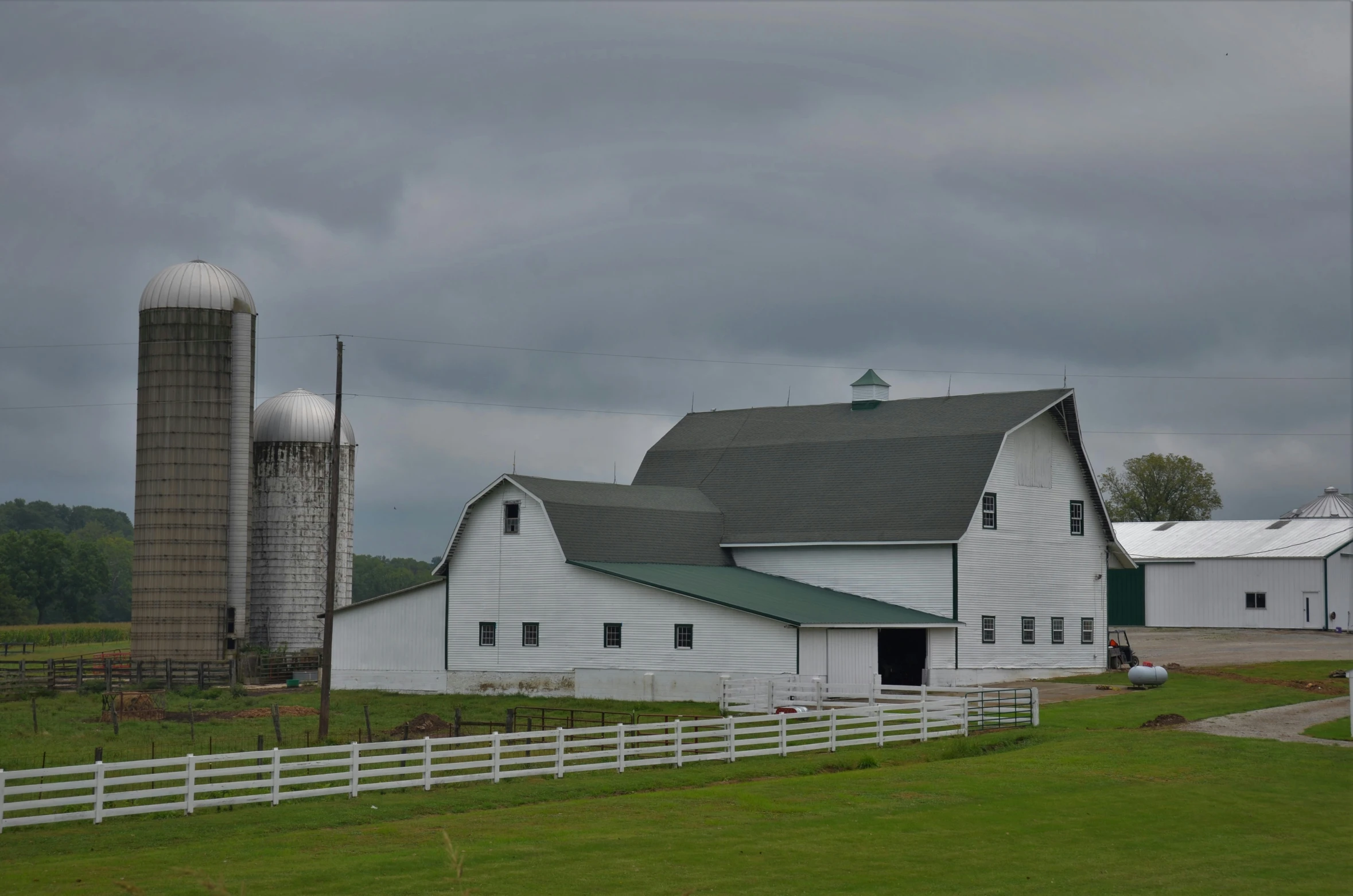 a large barn with two silos and a silo house