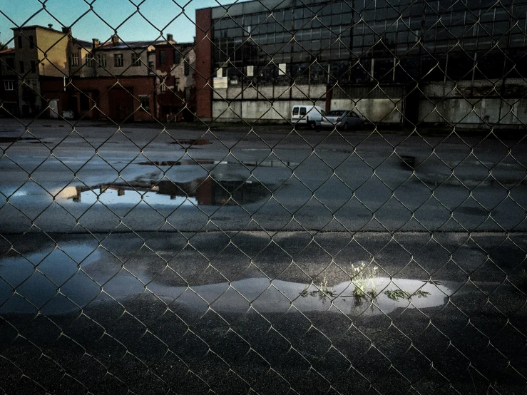 view through a chain link fence of some buildings and water