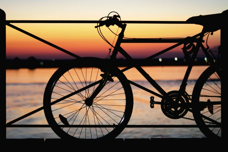 a bicycle is parked at the pier near the water