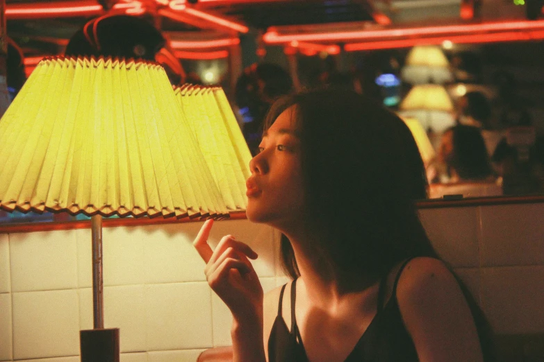 a woman looks up at the side of a lamp