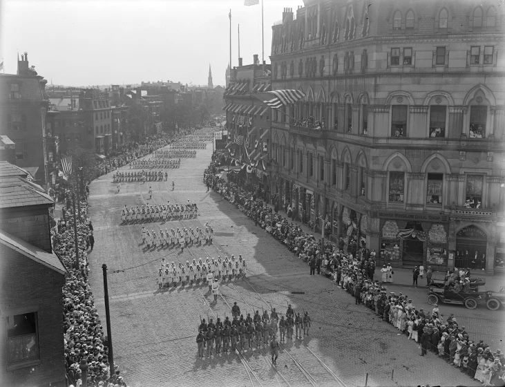 an old po of a group of people walking in a street