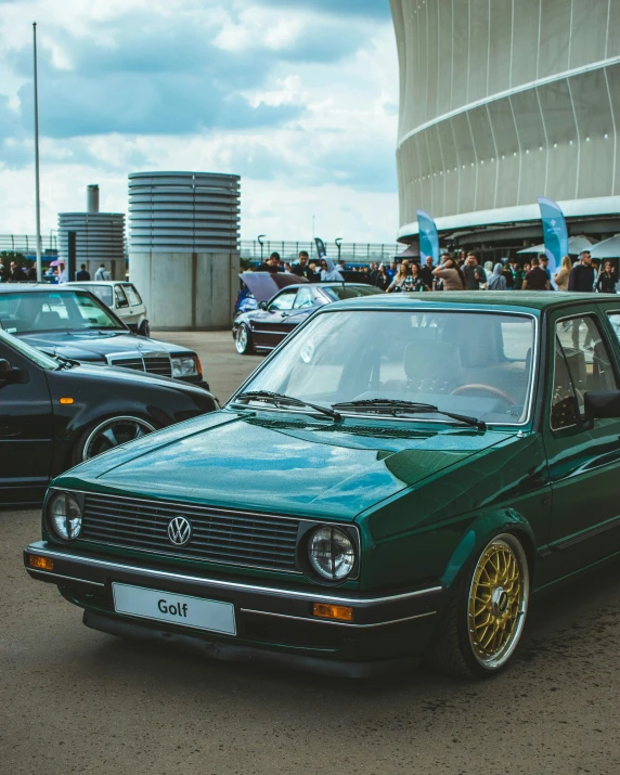 a green volkswagen is parked near several other cars