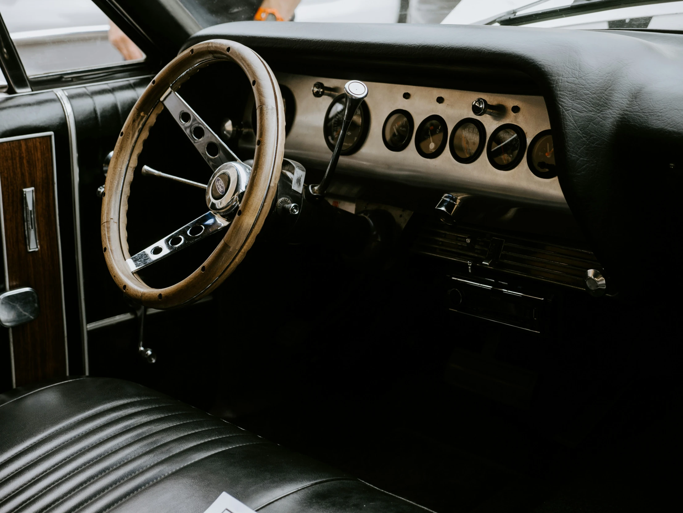 this is a car dashboard with wooden steering wheel controls