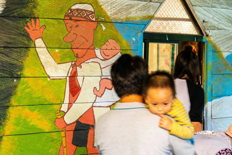 the family is gathered around a painted wall