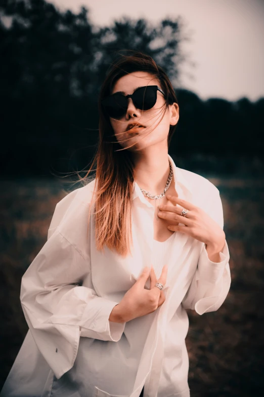 woman wearing sunglasses posing in a white shirt