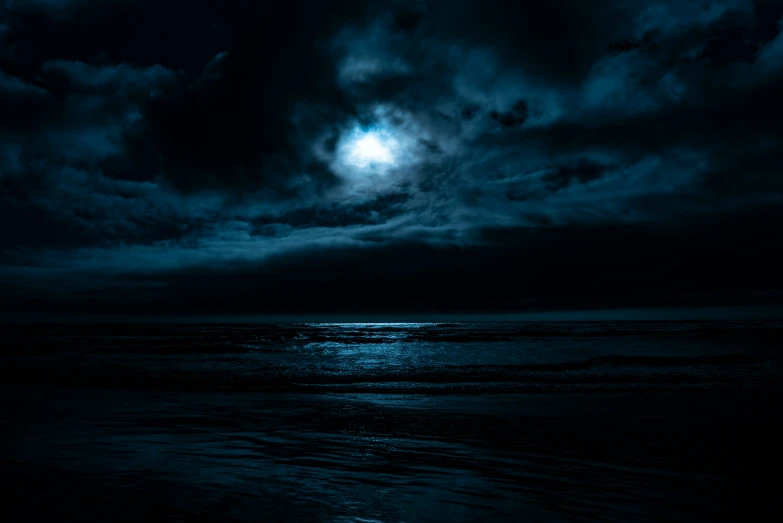 a dark and cloudy sky with moon shining through the clouds