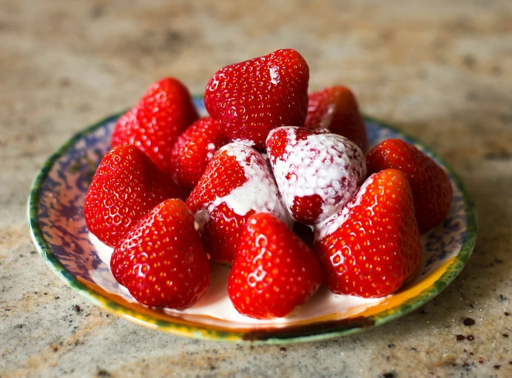 some strawberries that are in a colorful plate