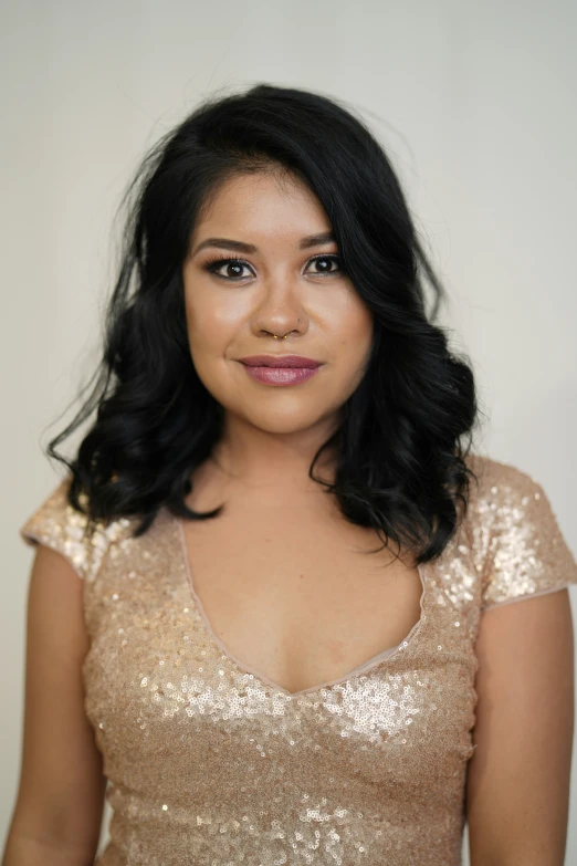 woman in golden sequinned dress smiling at the camera