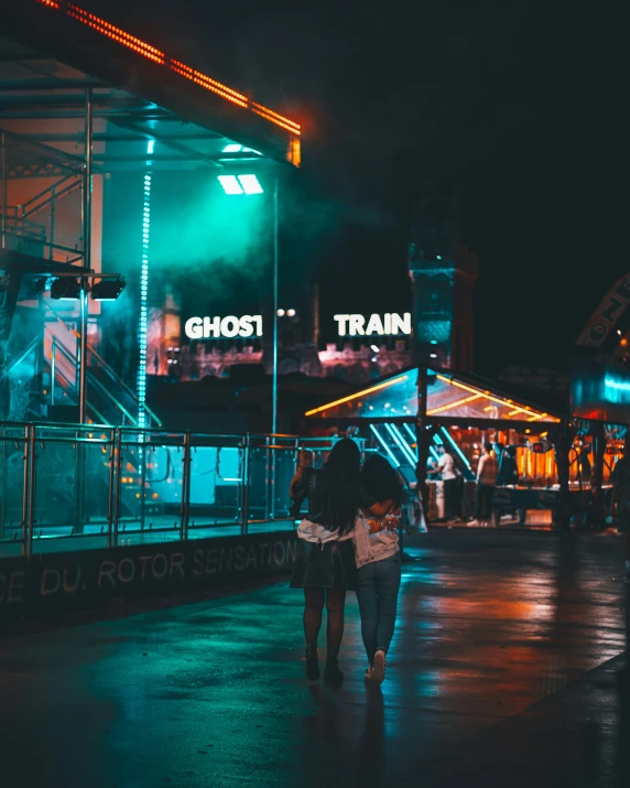 people are walking down the street at night