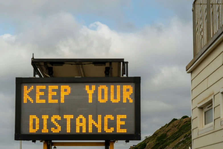 a sign that says keep your distance on the side of a building