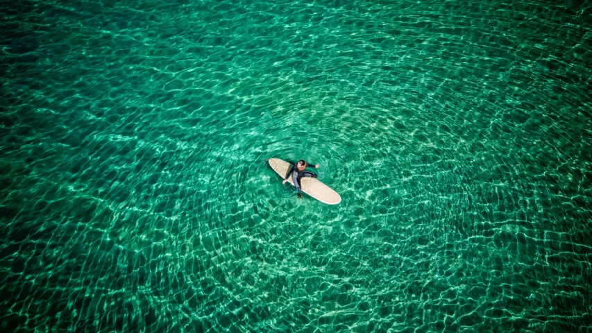 a person on a surfboard in clear water