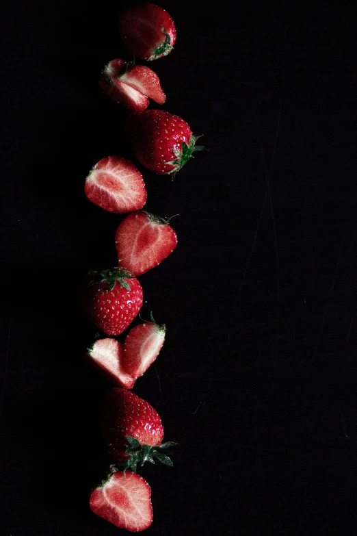 a string of strawberries on a dark background