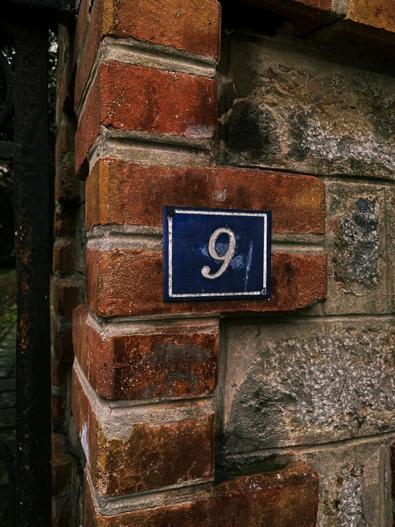 a blue sign that is on the side of a brick building