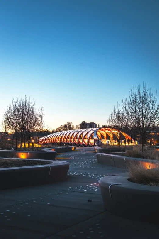 a walkway lined with small planters that glow in the evening