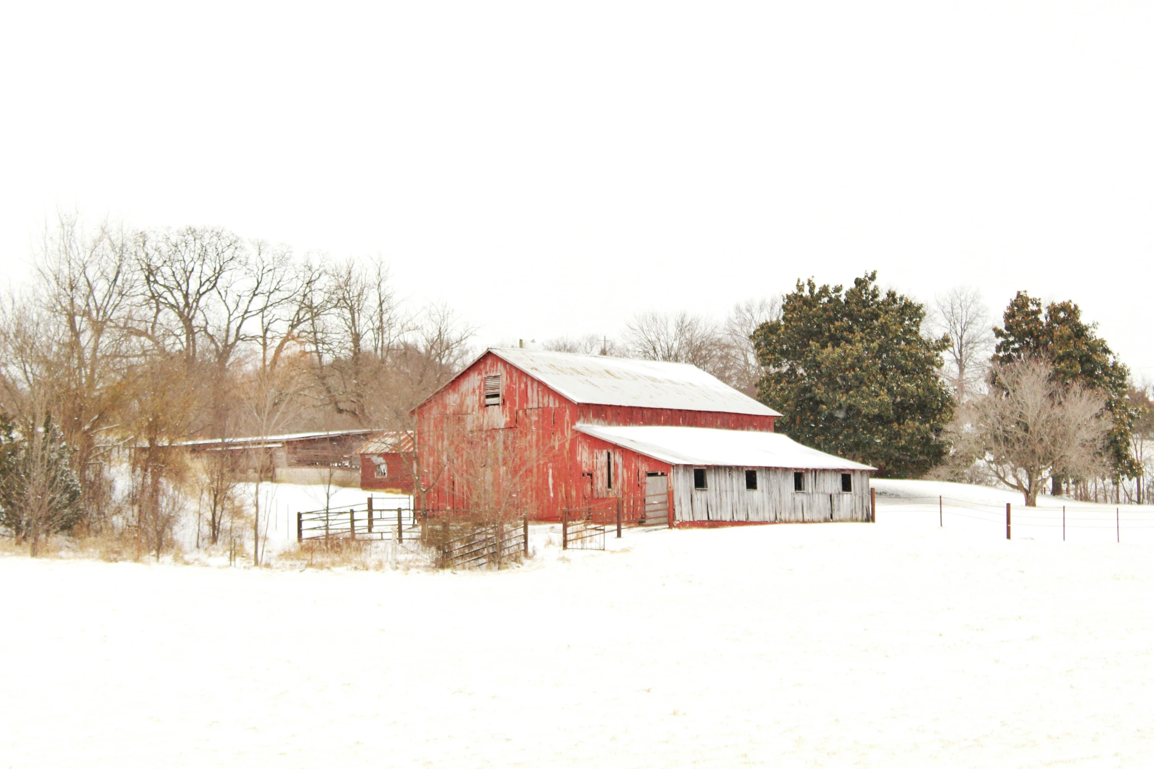 a red barn surrounded by a snowy field