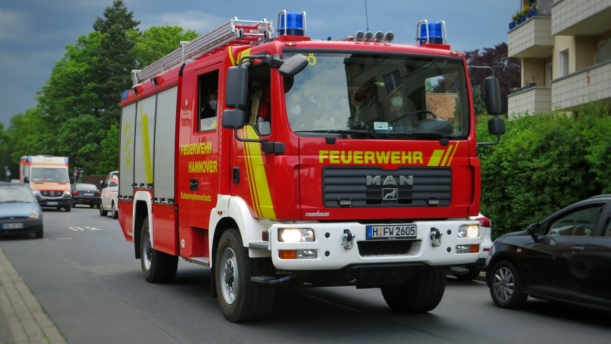 a large fire truck driving down the road next to a street